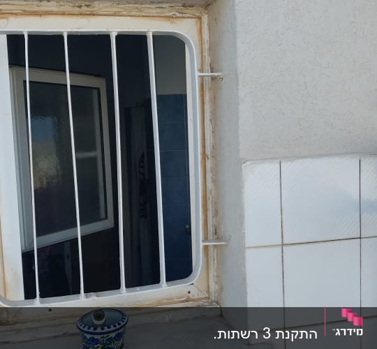 חלון עם סורגים מאלומיניום על קיר חיצוני